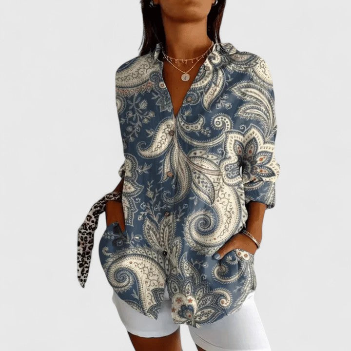 Isabel y Miguel Madrid Katarine floral blouse featuring light fabric and colorful flower patterns, displayed on a hanger.