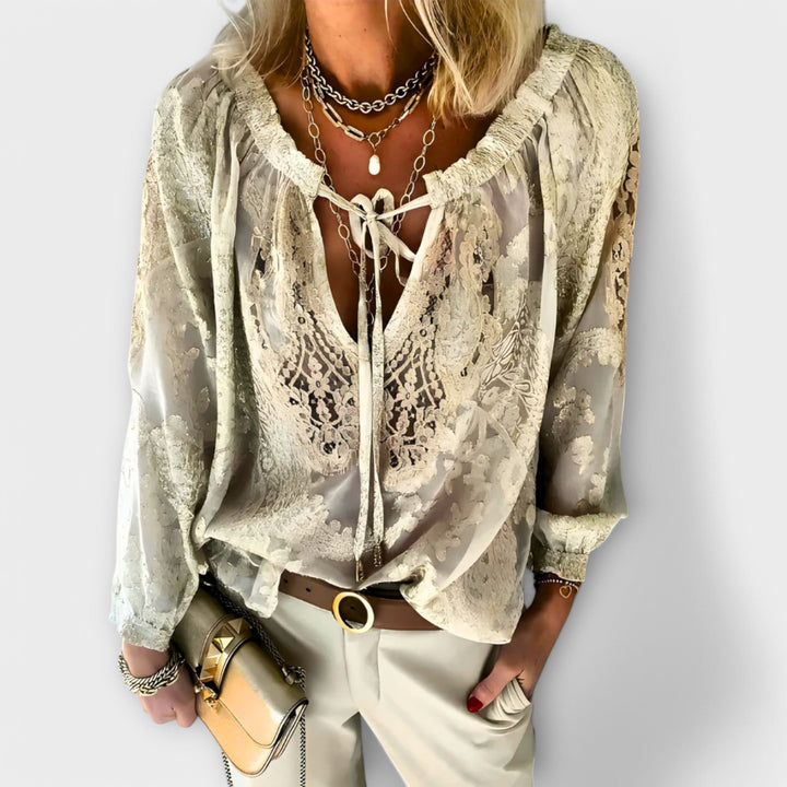 Elegant Isabel y Miguel Madrid Brunetta blouse with long sleeves and a classic design, worn by a model in a neutral setting.