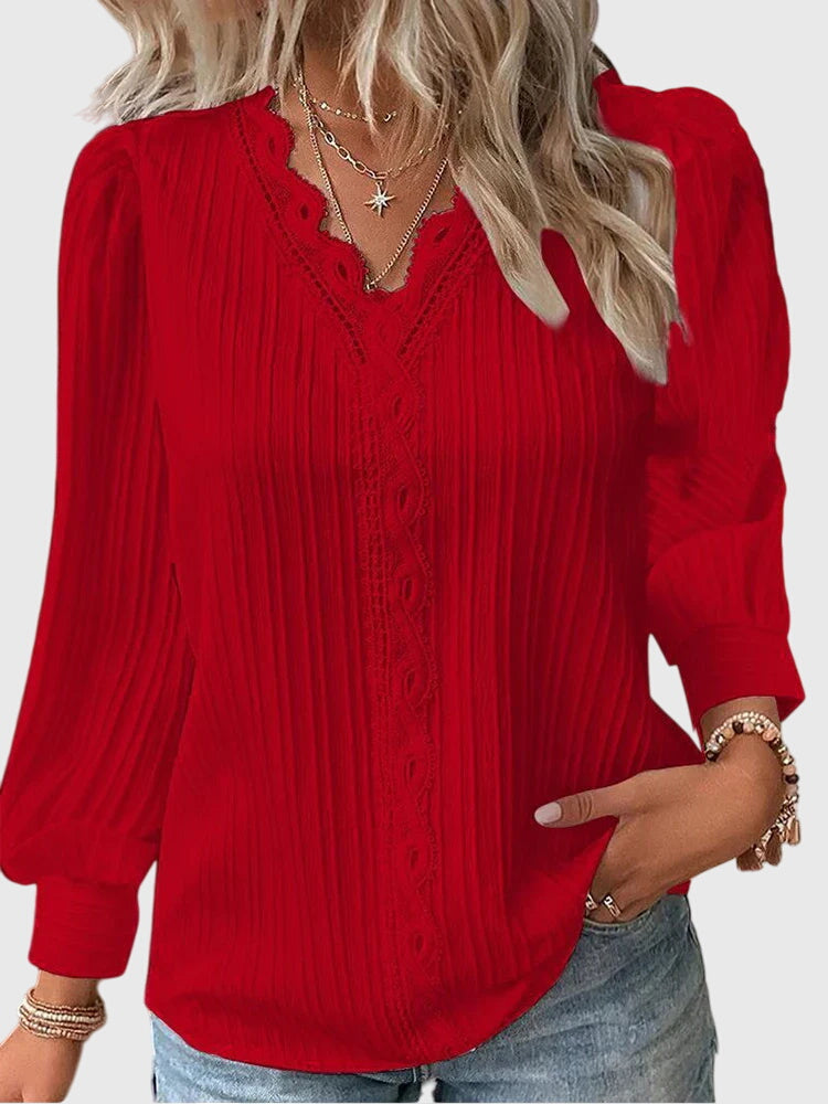 Andrea™ Isabel y Miguel Madrid elegant jersey blouse, soft fabric, long sleeves, and round neckline, displayed on a hanger.