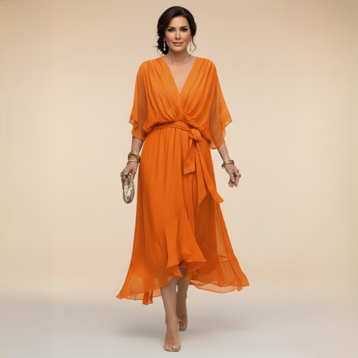 Isabel y Miguel Madrid Monica chiffon dress with V-neck, flowing fabric and elegant design, shown in a stylish fashion photo.