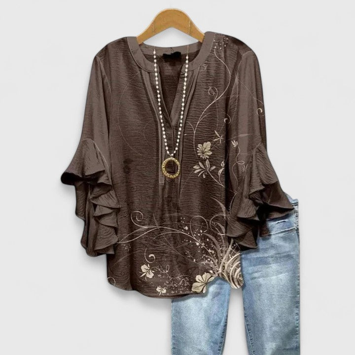 Isabel y Miguel Madrid Saryphiah comfortable blouse in light fabric, shown on a hanger with a simple, elegant design.