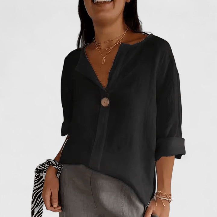 Elegant Kianna blouse by Isabel y Miguel Madrid, featuring a stylish design and high-quality fabric, displayed on a hanger.