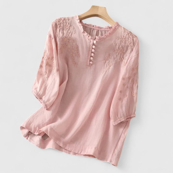 Vasilene Isabel y Miguel Madrid chic blouse with front buttons, featuring a stylish design, displayed on a hanger.