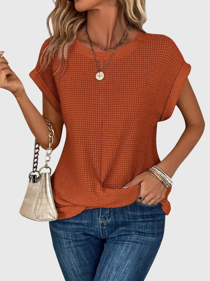 Isabel y Miguel Madrid Isa™ chic blouse with round neckline, soft fabric, and stylish design, shown on a hanger.