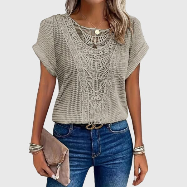 Isabel y Miguel Madrid Perla™ Ibiza-style elegant blouse with intricate embroidery and flowing fabric, modeled on a hanger.