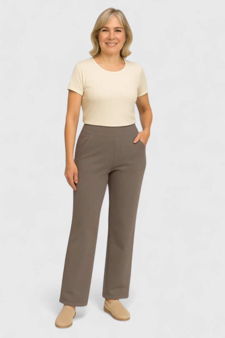 Mujer con pantalones elegantes en taupe de Isabel y Miguel Madrid, mostrando estilo y comodidad en fondo de estudio.